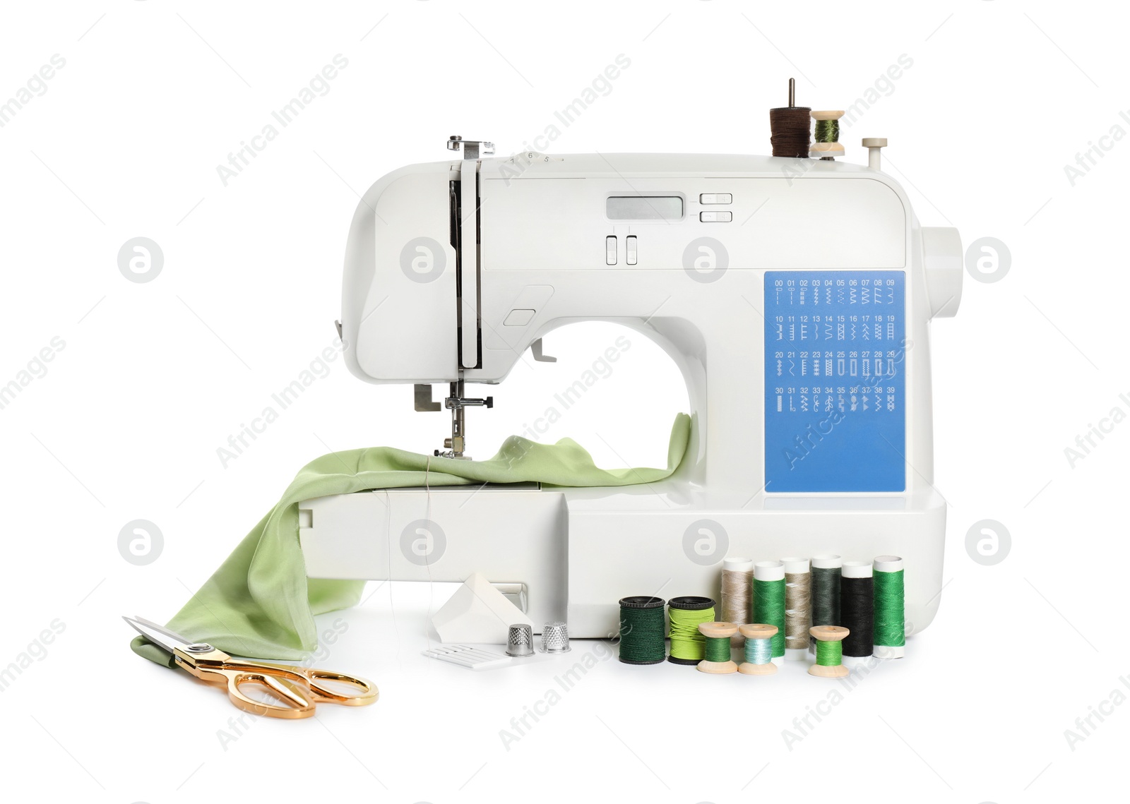 Photo of Modern sewing machine with light green cloth and craft accessories isolated on white