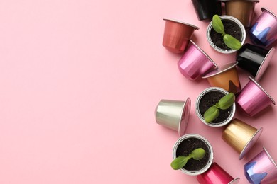 Photo of Coffee capsules and seedlings on pink background, flat lay. Space for text