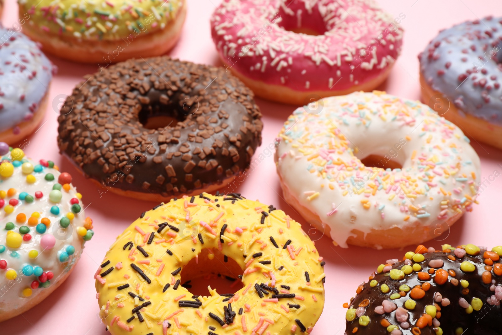 Photo of Delicious glazed donuts on pink background, closeup
