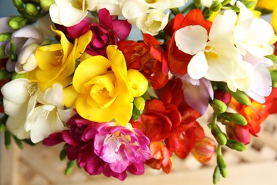 Photo of Beautiful spring freesia flowers on stand, closeup