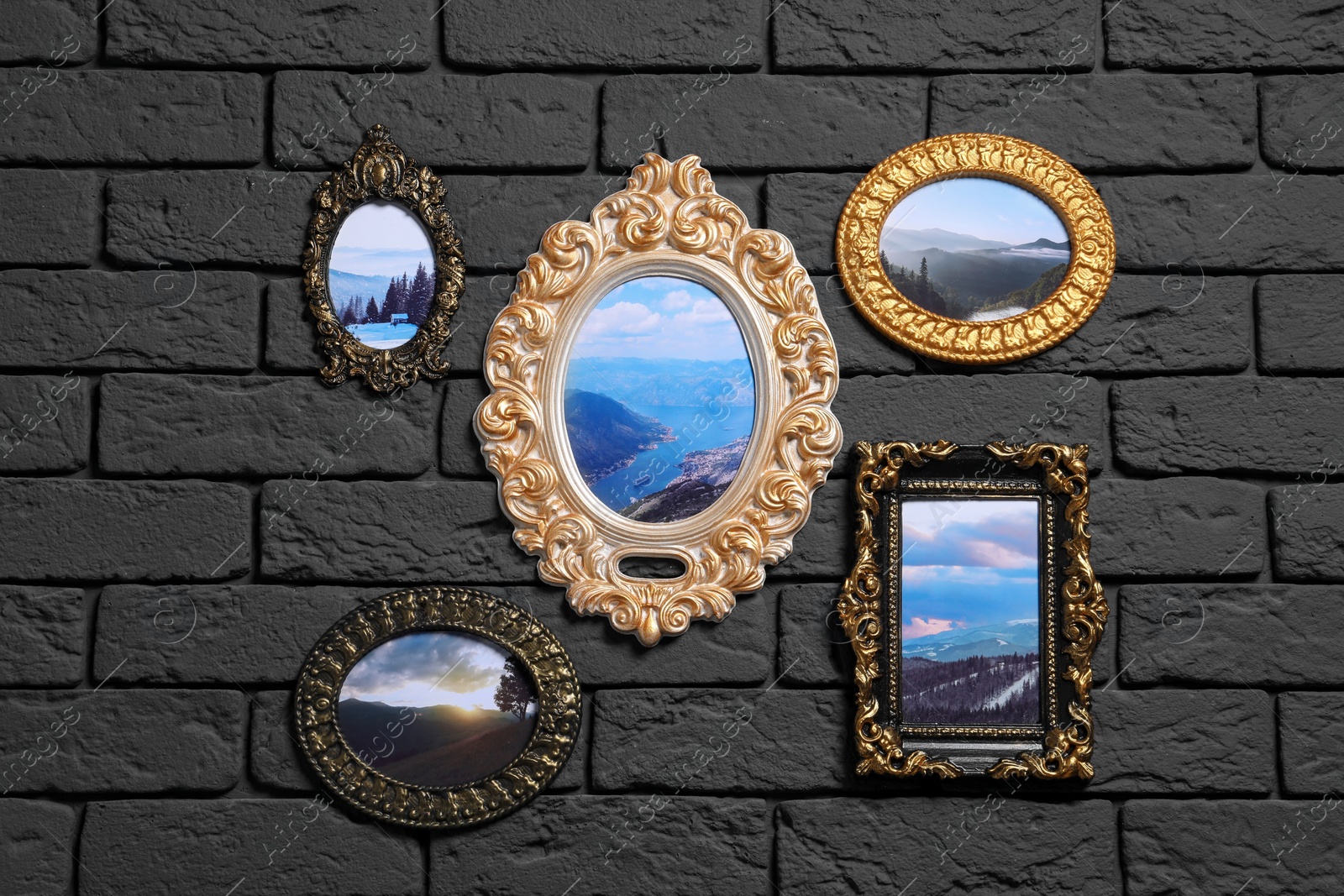 Photo of Vintage frames with photos of beautiful landscapes hanging on dark brick wall