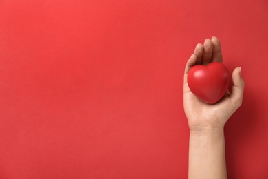 Photo of Woman holding decorative heart on red background, top view with space for text. Happy Valentine's Day