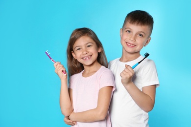 Portrait of cute children with toothbrushes on color background