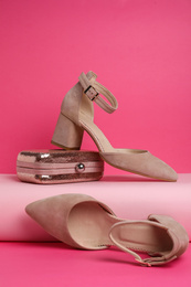 Photo of Stylish female shoes and bag on pink background