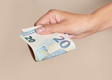 Photo of Woman with Euro banknotes on brown background, closeup