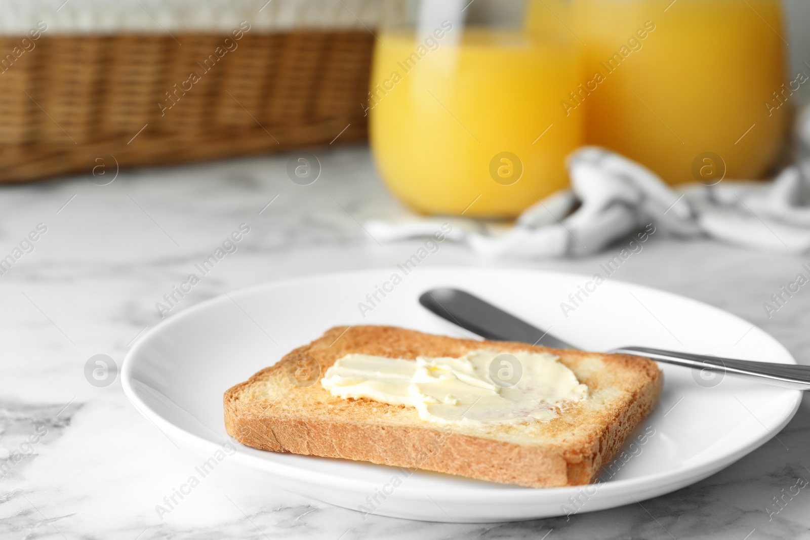 Photo of Slice of toasted bread with butter on white marble table