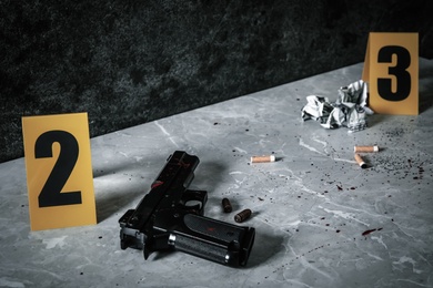 Photo of Crime scene markers and evidences on light grey marble table