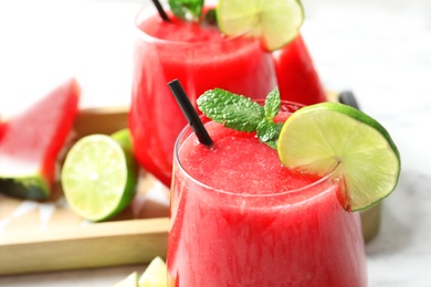 Summer watermelon drink with mint and lime in glass on table, closeup