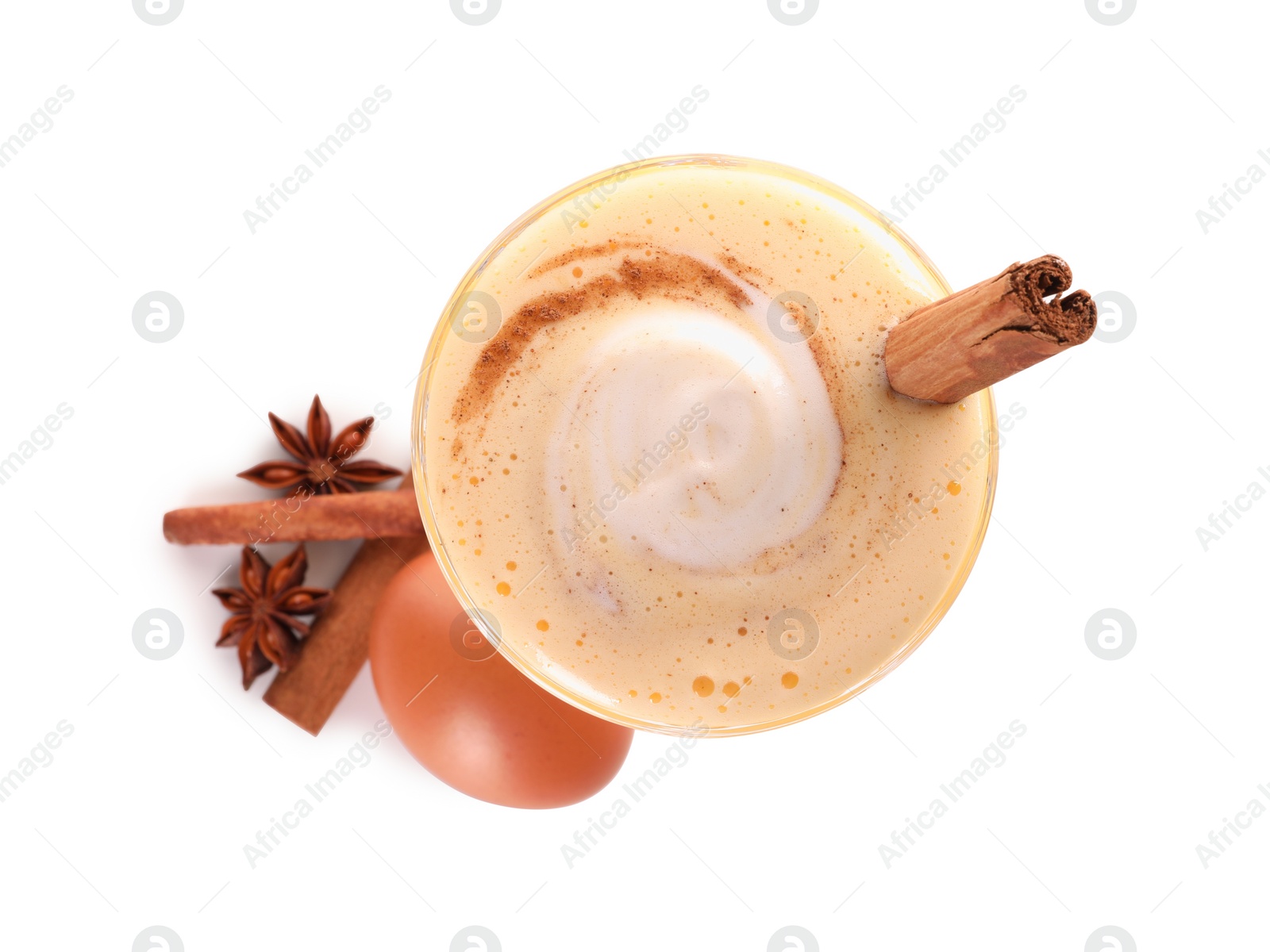 Photo of Delicious eggnog in glass, spices and egg isolated on white, top view