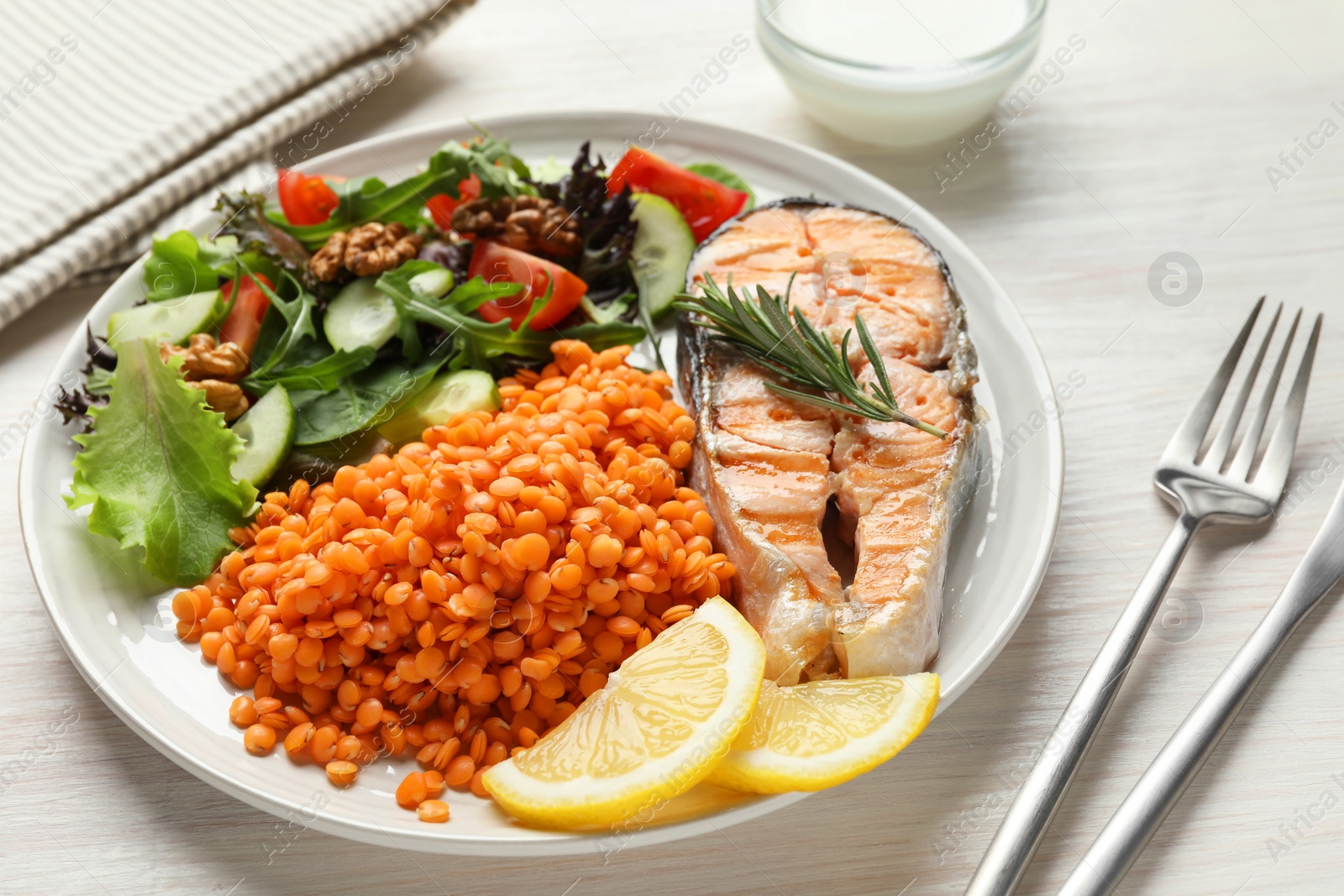 Photo of Plate with healthy food high in vegetable fats served on light wooden table, closeup