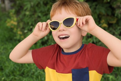 Photo of Cute little boy with sunglasses in park