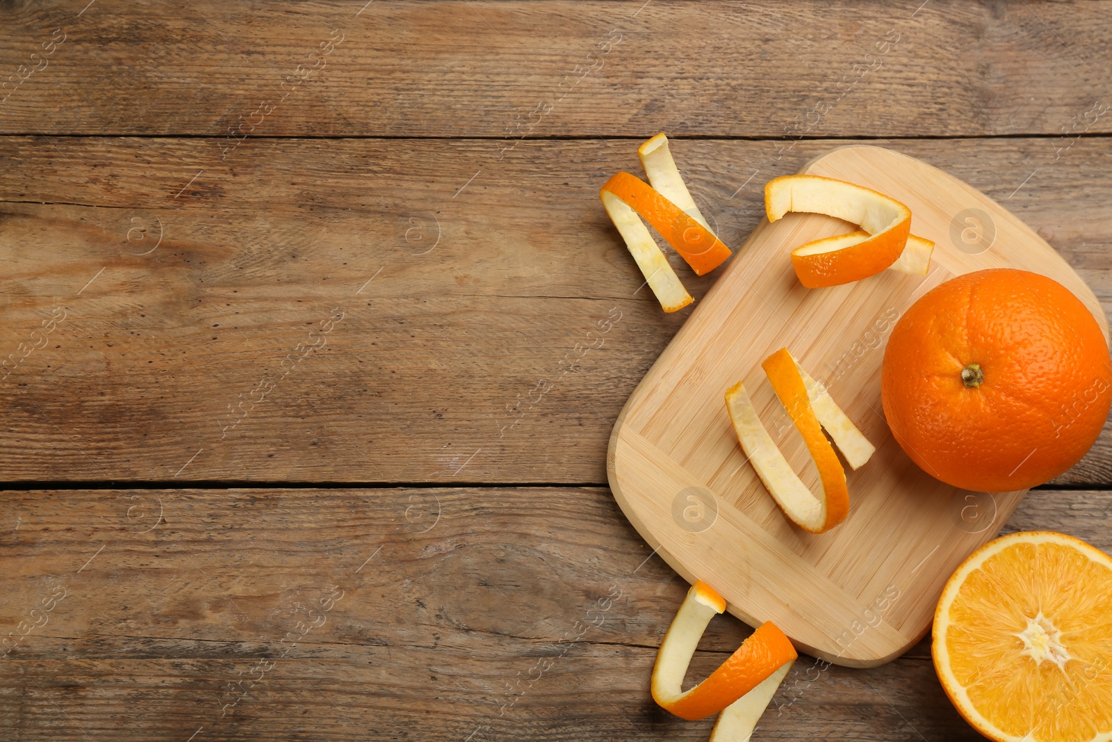 Photo of Orange peels and fruits on wooden table, flat lay. Space for text