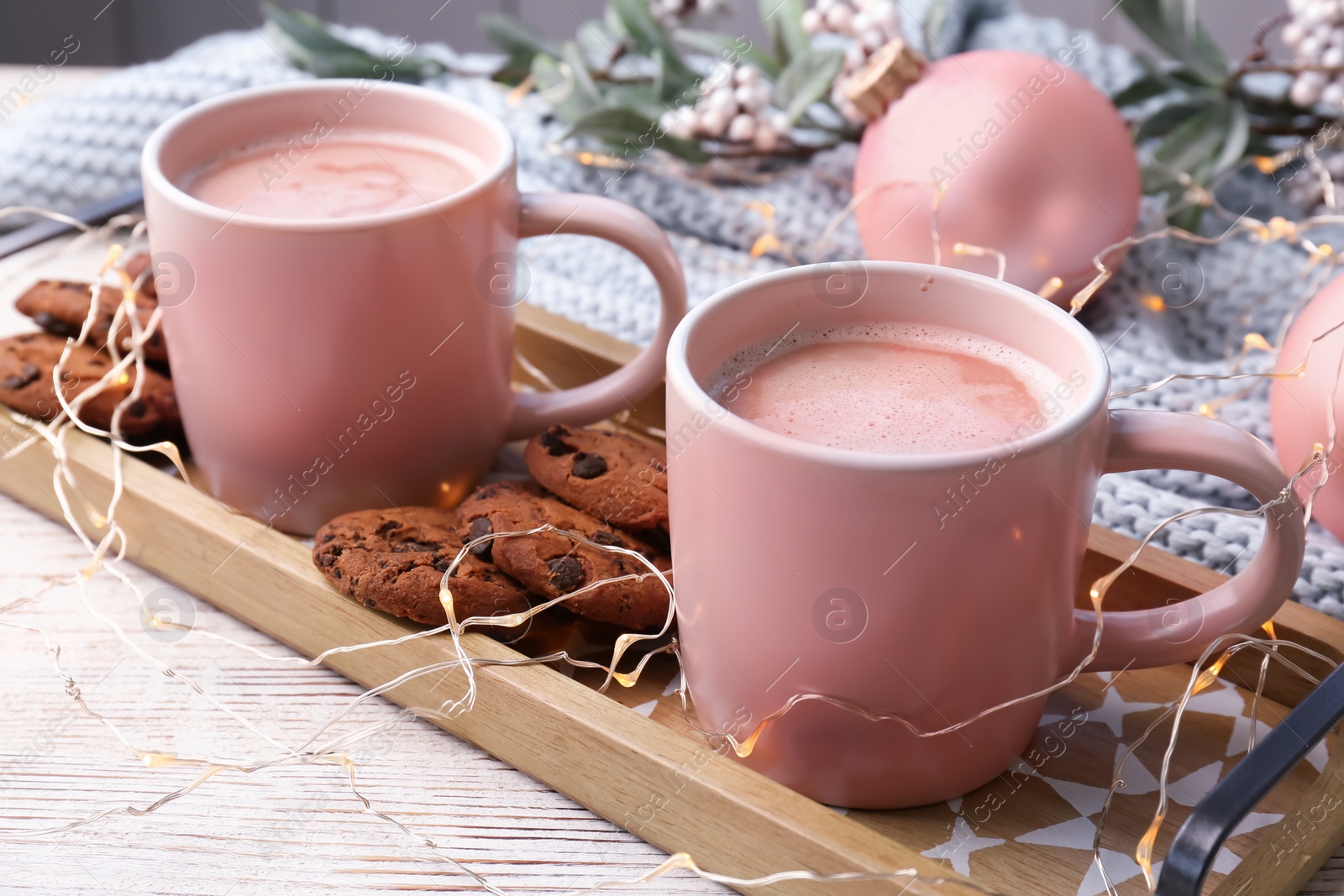 Photo of Tray with tasty cookies and cups of hot cocoa drink on table