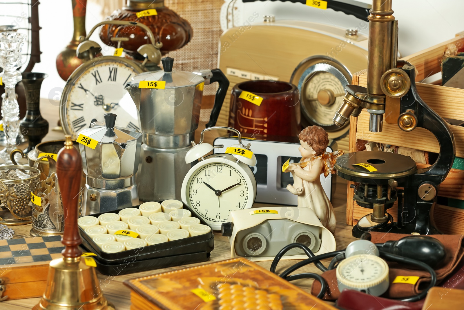 Photo of Many different items on wooden table indoors. Garage sale