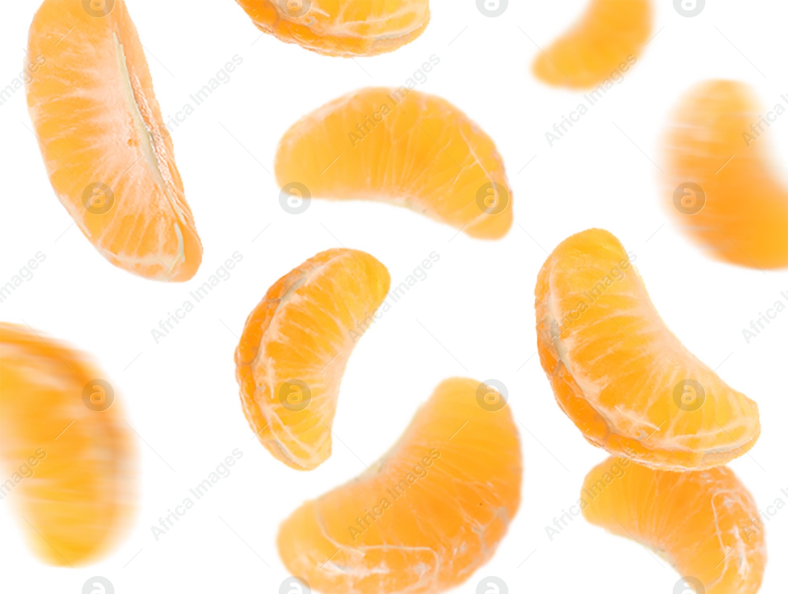 Image of Peeled fresh tangerine pieces falling on white background