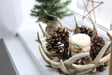 Photo of Beautiful candle holder and other Christmas decorations on window sill
