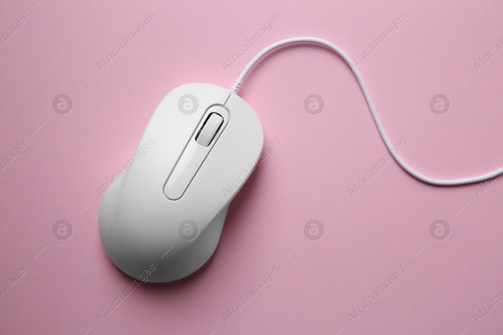 Photo of One wired mouse on pink background, top view