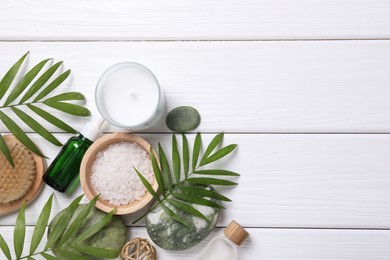 Flat lay composition with candle and different spa products on white wooden table. Space for text