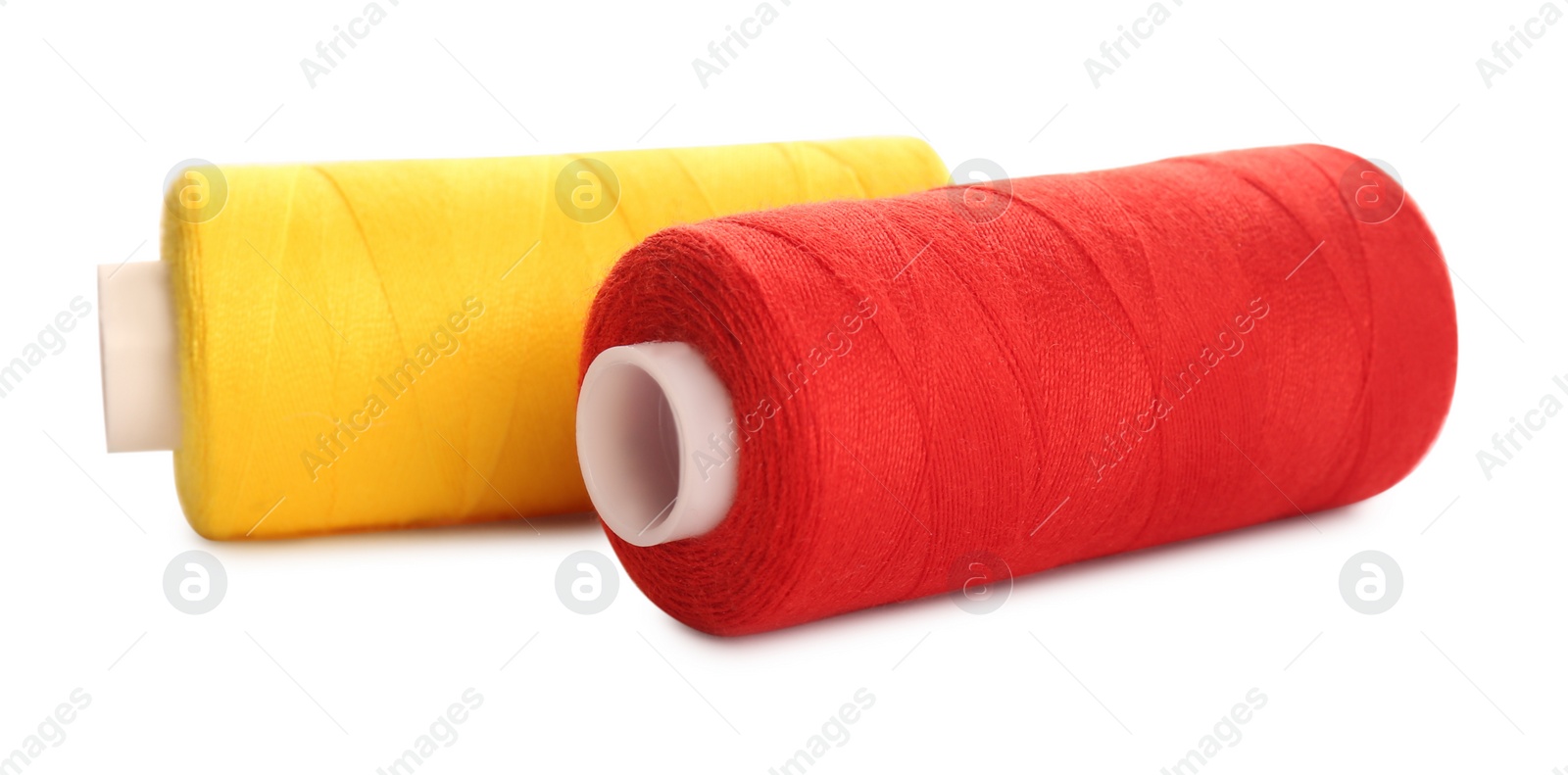 Photo of Different colorful sewing threads on white background, closeup