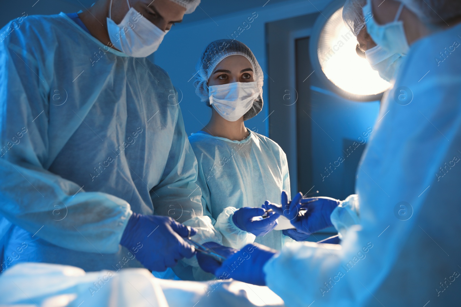Photo of Team of professional surgeons performing operation in clinic