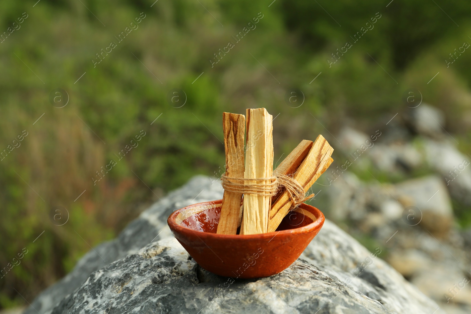 Photo of Many palo santo sticks on stone surface outdoors