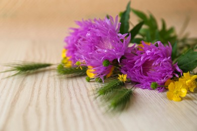 Photo of Bouquet of beautiful wildflowers on wooden table, closeup