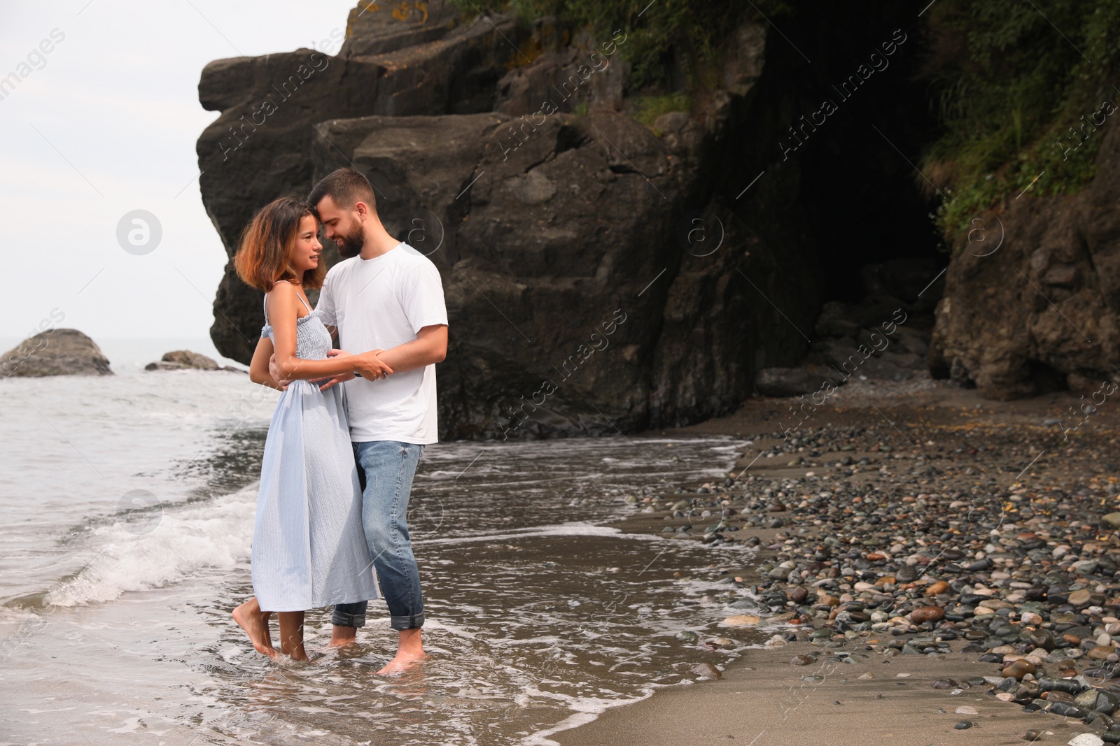 Photo of Young couple on beach near sea. Space for text