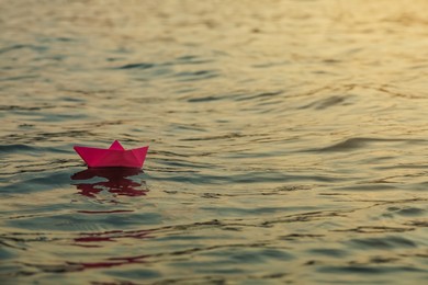 Photo of Paper boat floating on water outdoors. Space for text