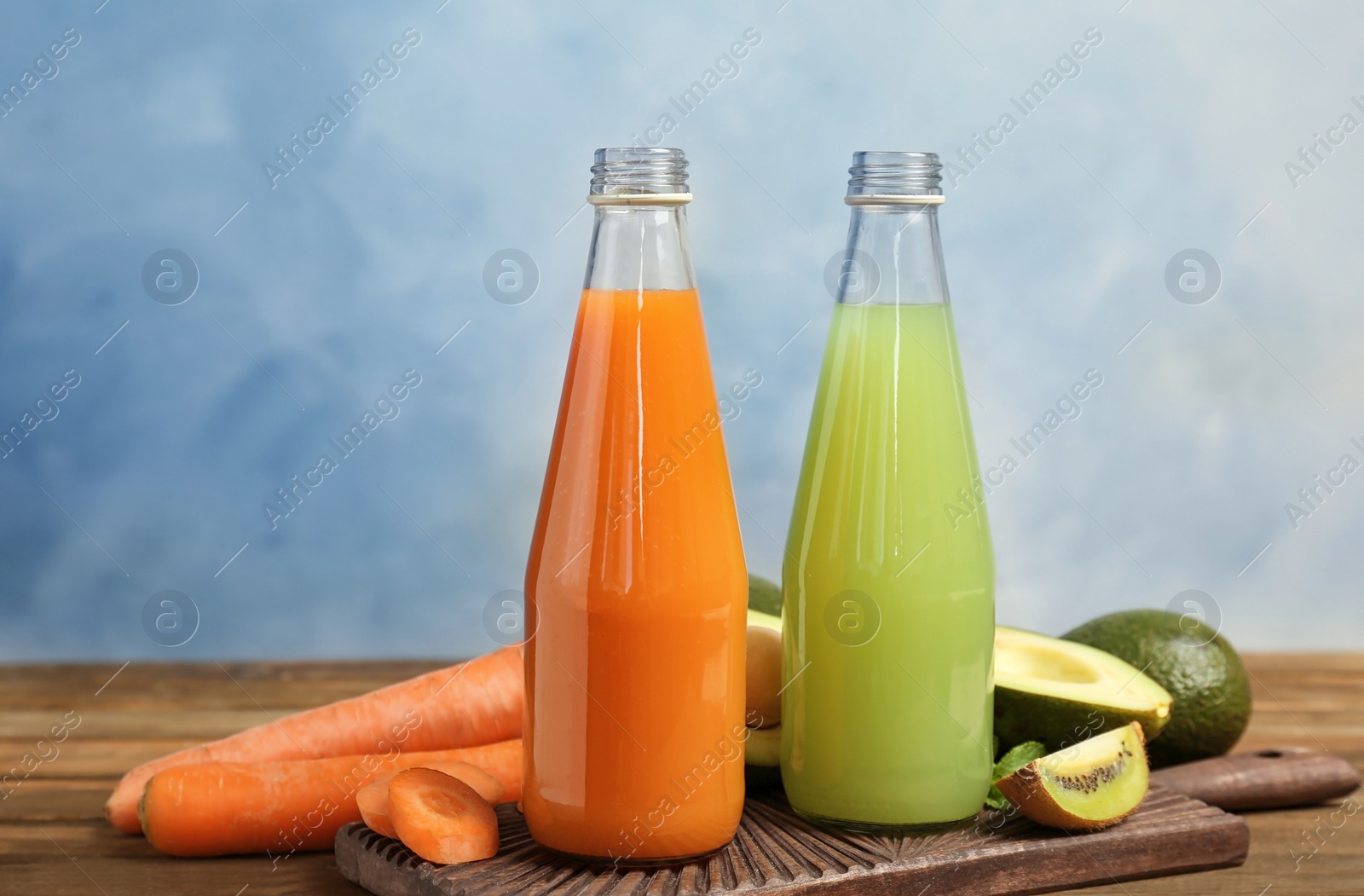 Photo of Bottles with tasty juices and ingredients on table