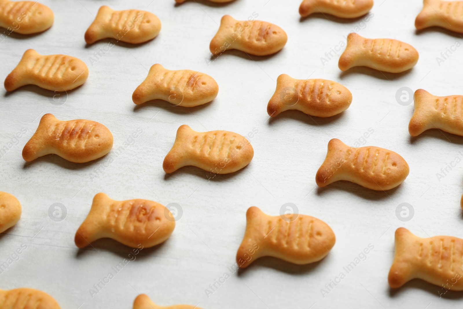 Photo of Delicious fish shaped crackers on white table, closeup