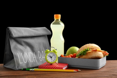 Photo of Lunch box with appetizing food and bag on table