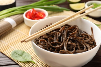 Photo of Tasty buckwheat noodles (soba) served on table, closeup