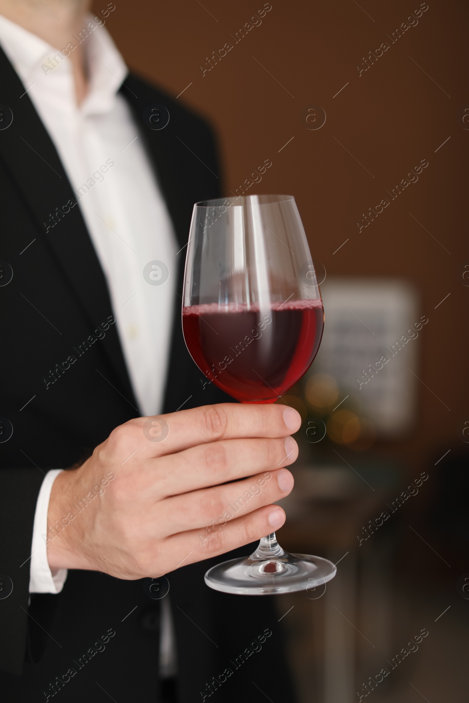 Photo of Young man with glass of wine indoors