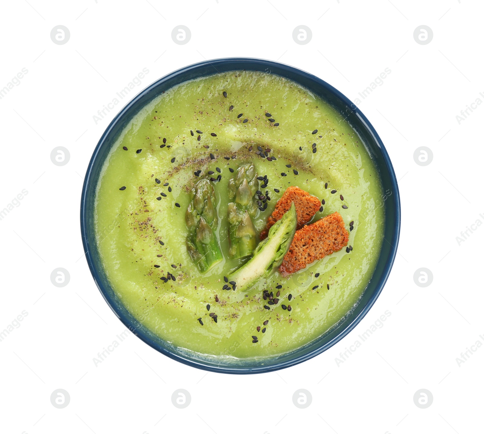 Photo of Delicious asparagus soup with rusks and sesame seeds isolated on white, top view