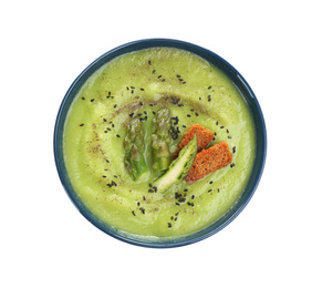 Photo of Delicious asparagus soup with rusks and sesame seeds isolated on white, top view