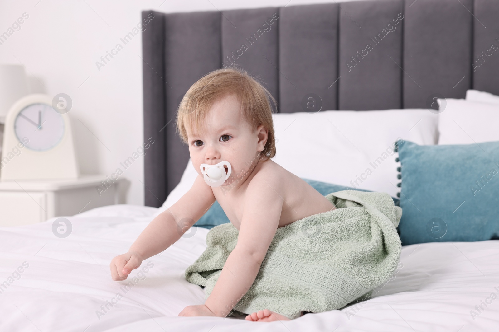 Photo of Cute little baby with towel after bathing on bed