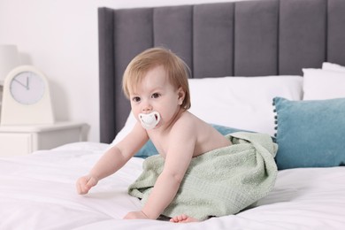 Photo of Cute little baby with towel after bathing on bed