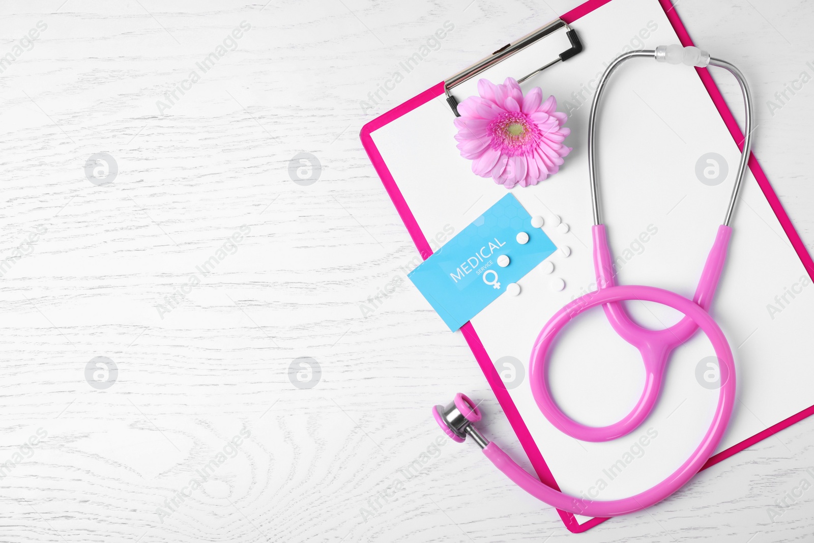 Photo of Flat lay composition with clipboard and stethoscope on white wooden background, space for text. Gynecology concept