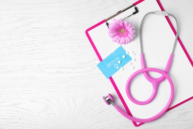 Flat lay composition with clipboard and stethoscope on white wooden background, space for text. Gynecology concept