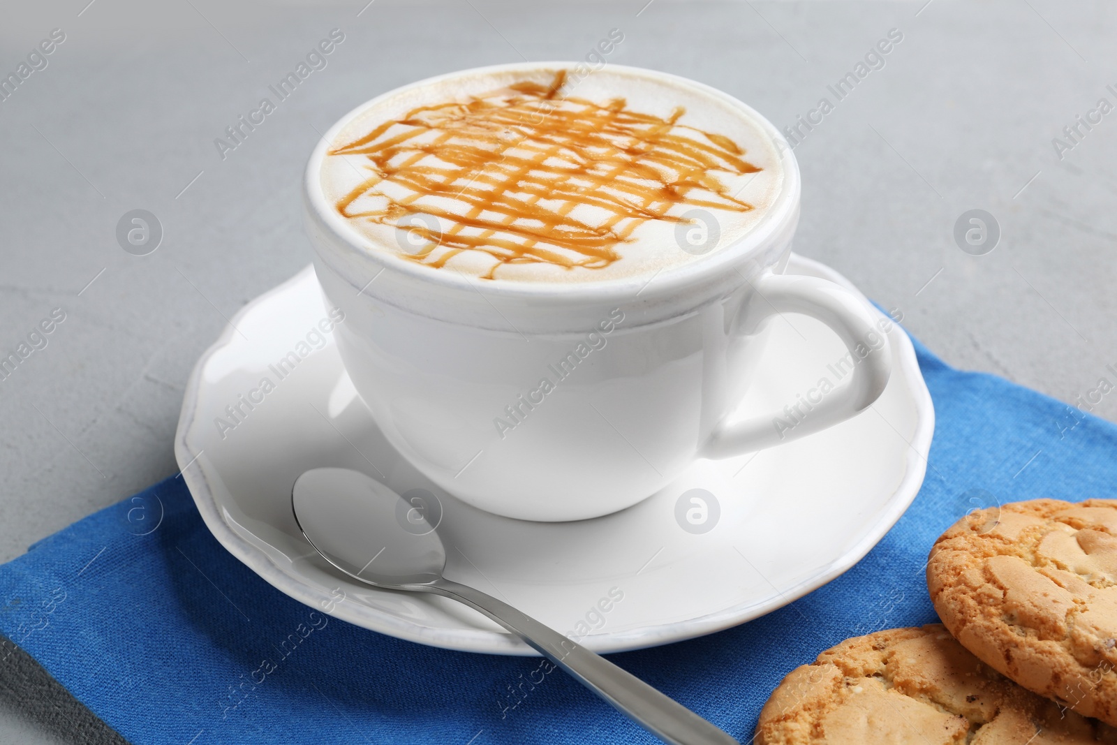 Photo of Cup of caramel macchiato and tasty pastry on table