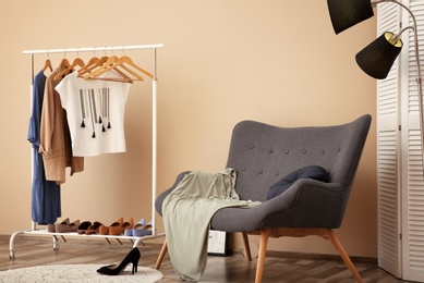 Wardrobe rack with female clothes in stylish dressing room