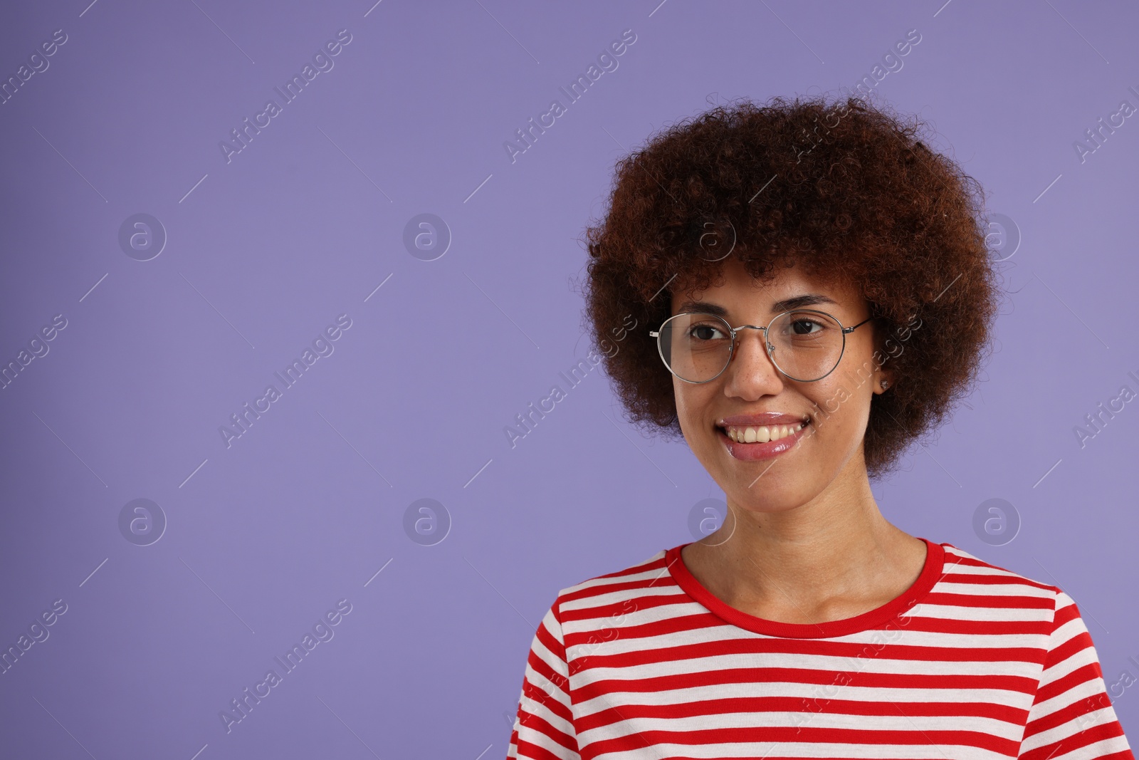 Photo of Portrait of happy young woman in eyeglasses on purple background. Space for text