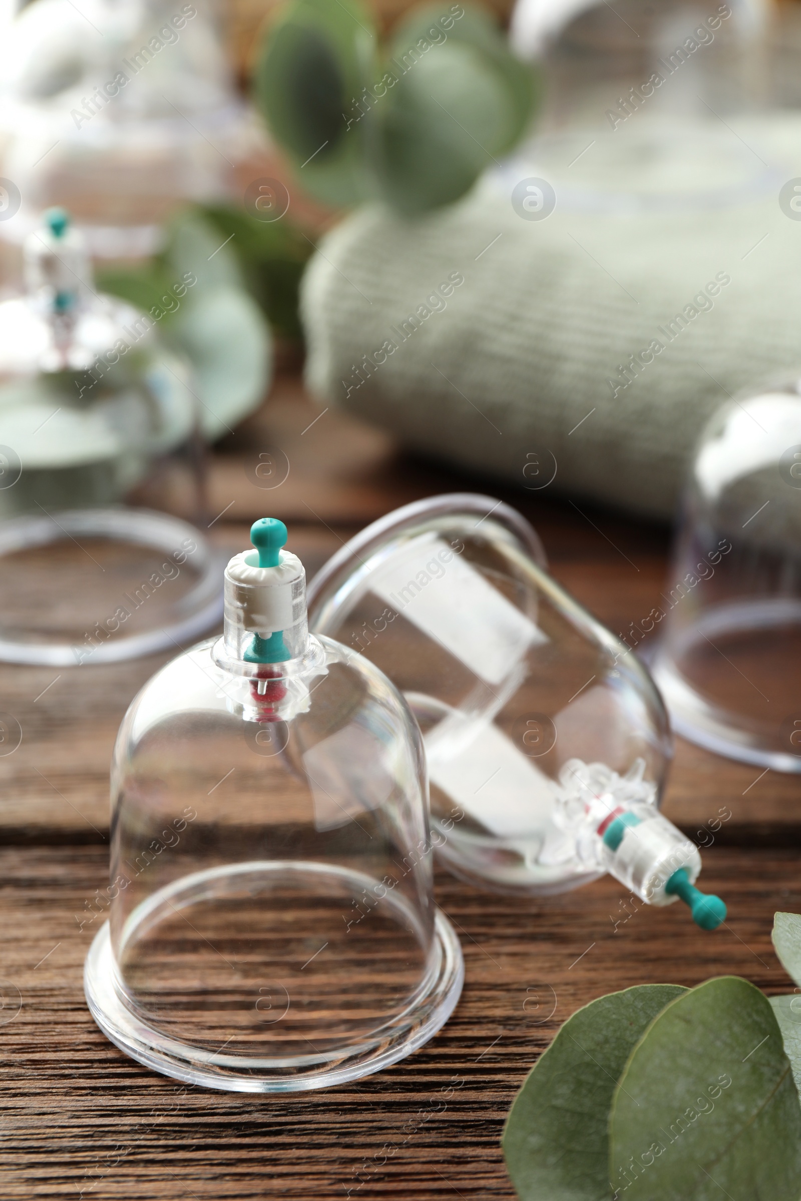 Photo of Plastic cups on wooden table, closeup. Cupping therapy