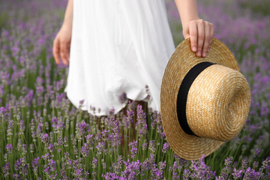 Young woman with straw hat in lavender field, closeup