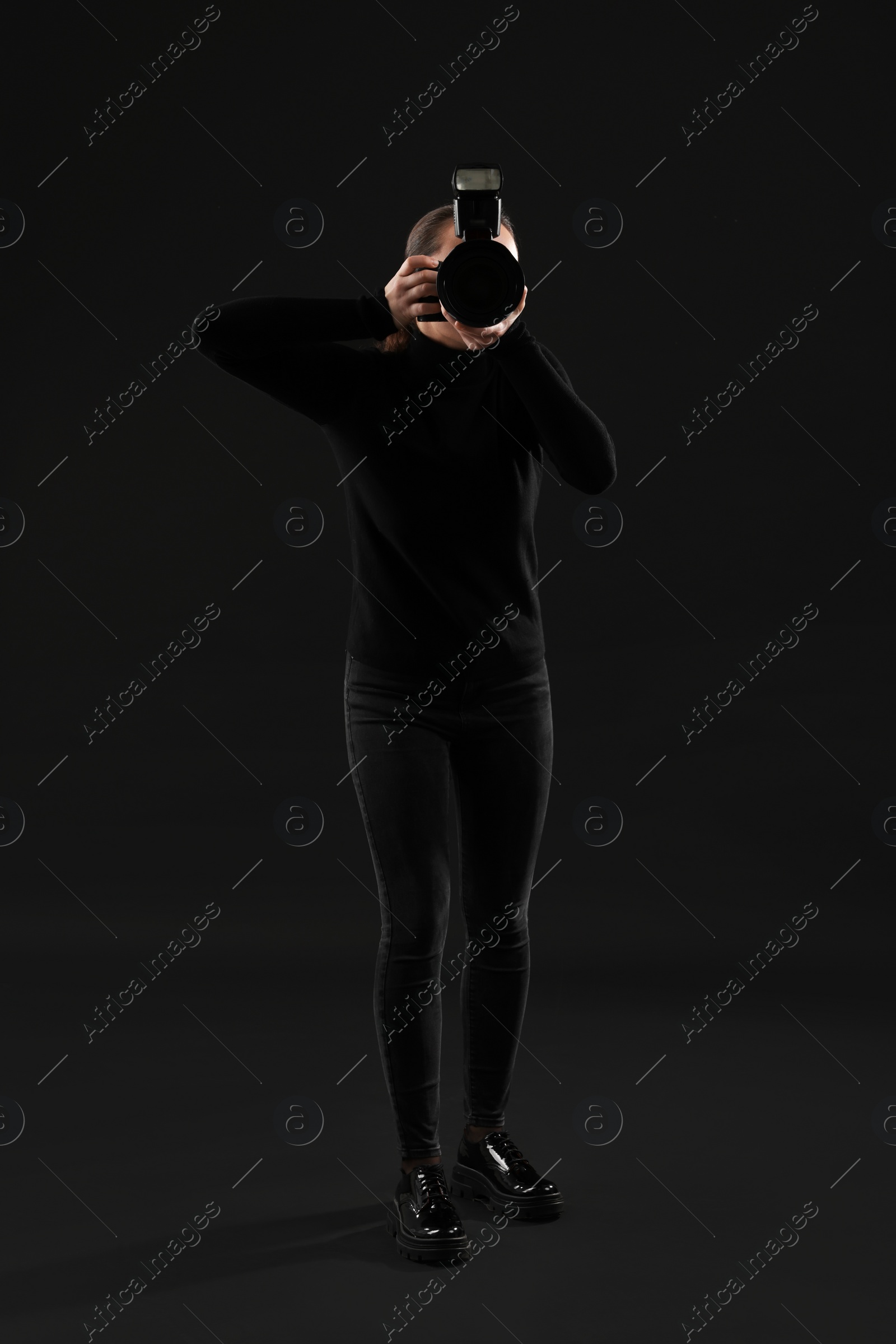 Photo of Professional photographer taking picture on black background