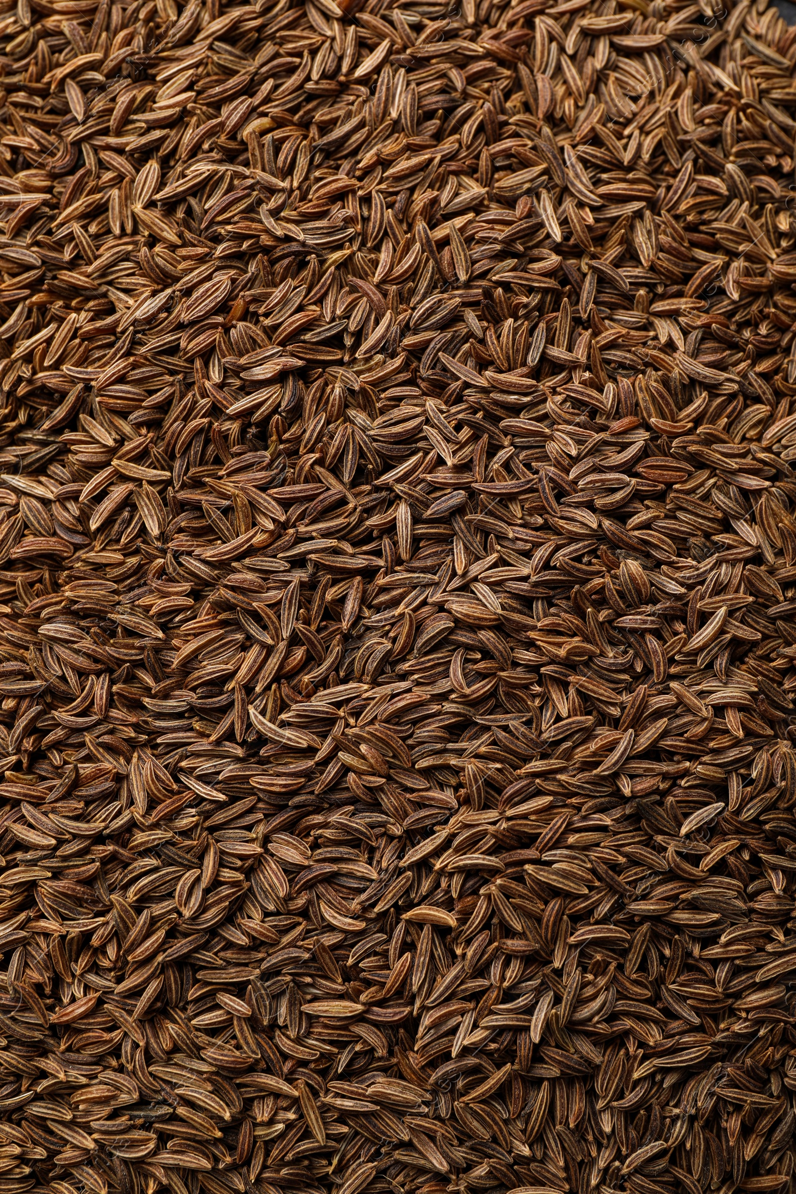 Photo of Aromatic cumin seeds as background, top view