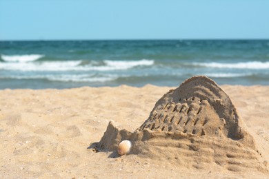 Photo of Beach with sand castle near sea on sunny day. Space for text