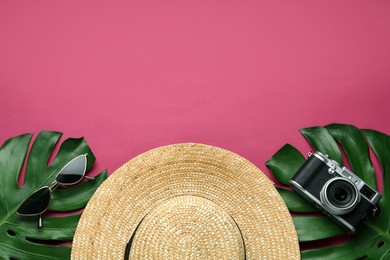 Flat lay composition with straw hat on crimson background. Space for text
