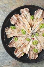 Tasty pickled anchovies with spices on textured table, top view