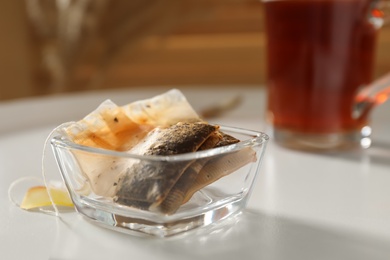 Photo of Glass bowl with used tea bags on white table